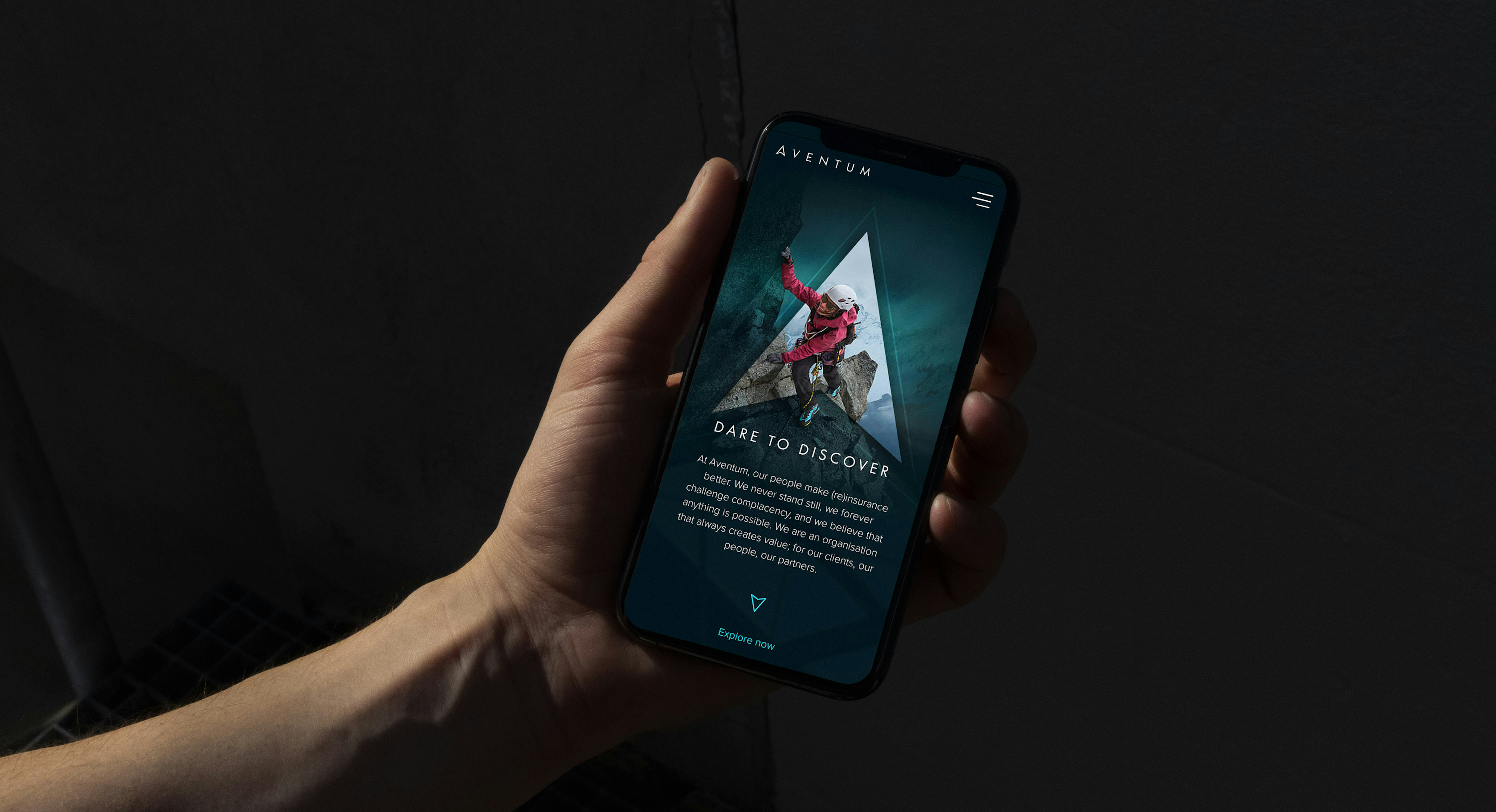 A hand holding a mobile phone that is displaying the hero section of Aventum website