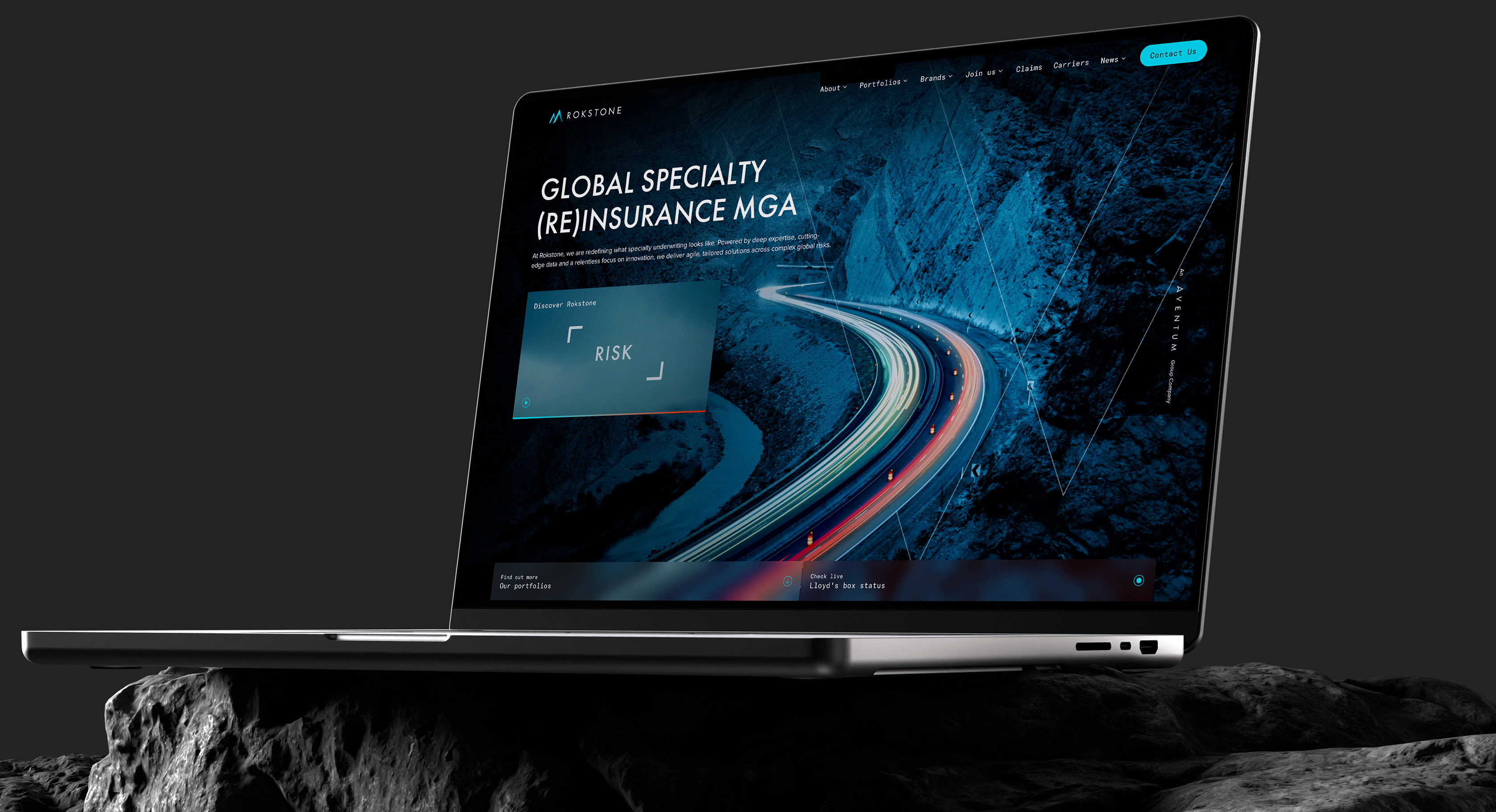 A laptop screen displaying the new Rokstone website homepage, featuring a bold 'Global Specialty (Re)insurance MGA' headline with high-quality video backgrounds and modern typography.