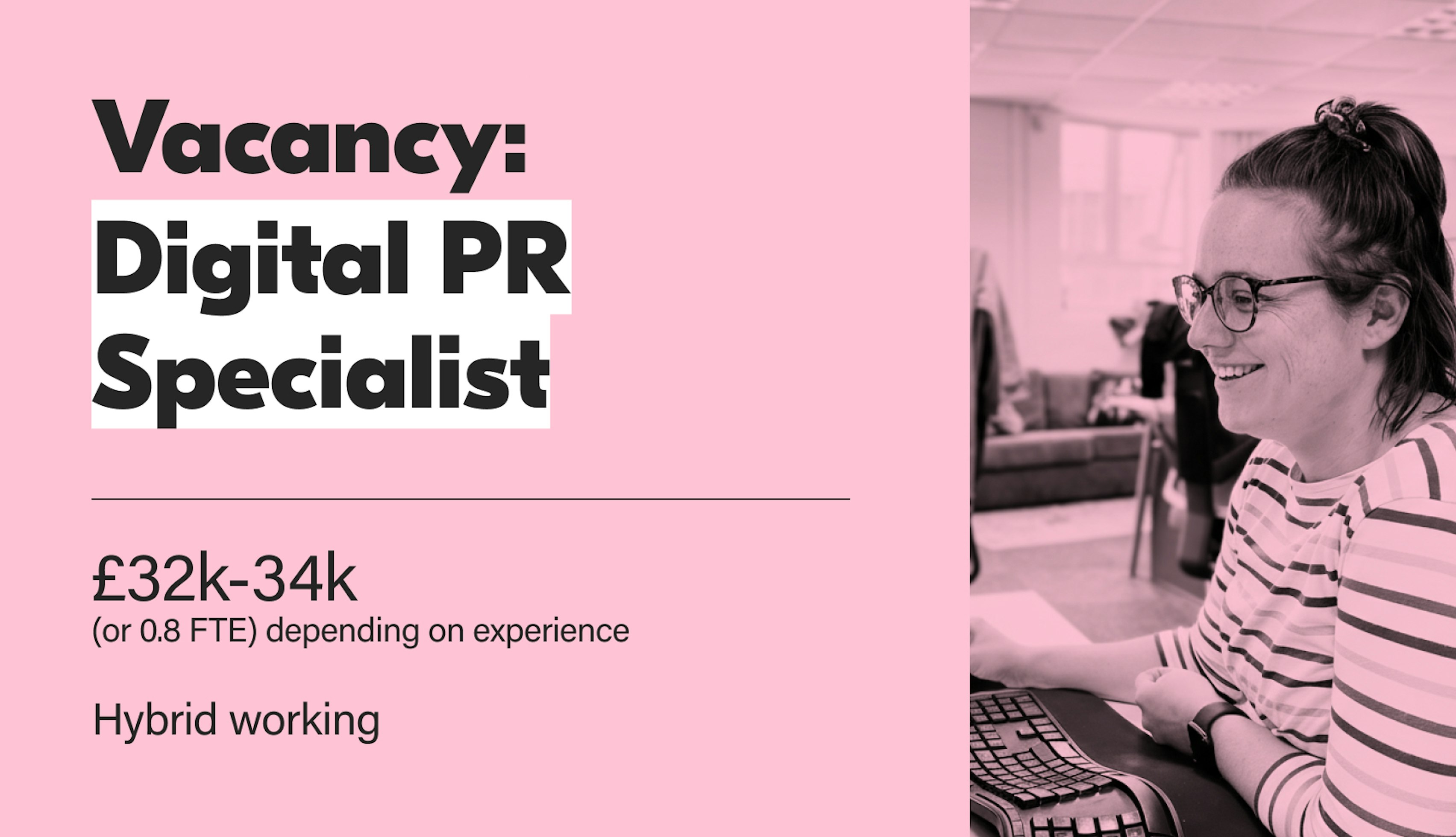 A promotional image for a Digital PR Specialist job vacancy. The left side features large white text on a light pink background announcing: Vacancy: Digital PR Specialist, with the salary range of £32k-34k (or 0.8 FTE depending on experience), and Hybrid working listed below. The right side is a black and white photo of a smiling woman with glasses, wearing a striped top and her hair tied up, sitting at a desk and looking at a computer screen.