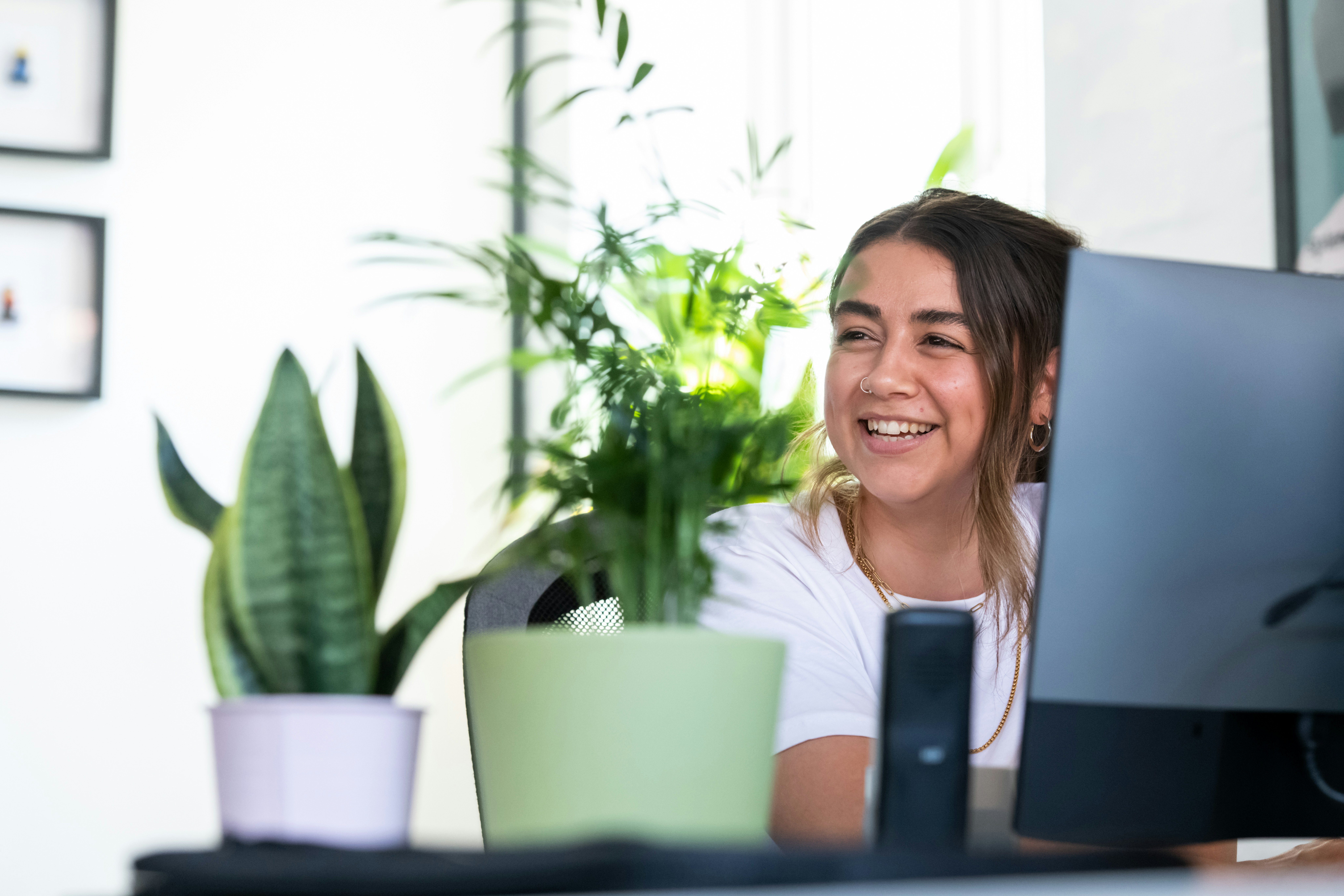 Smiling female sitting at a computer in an office