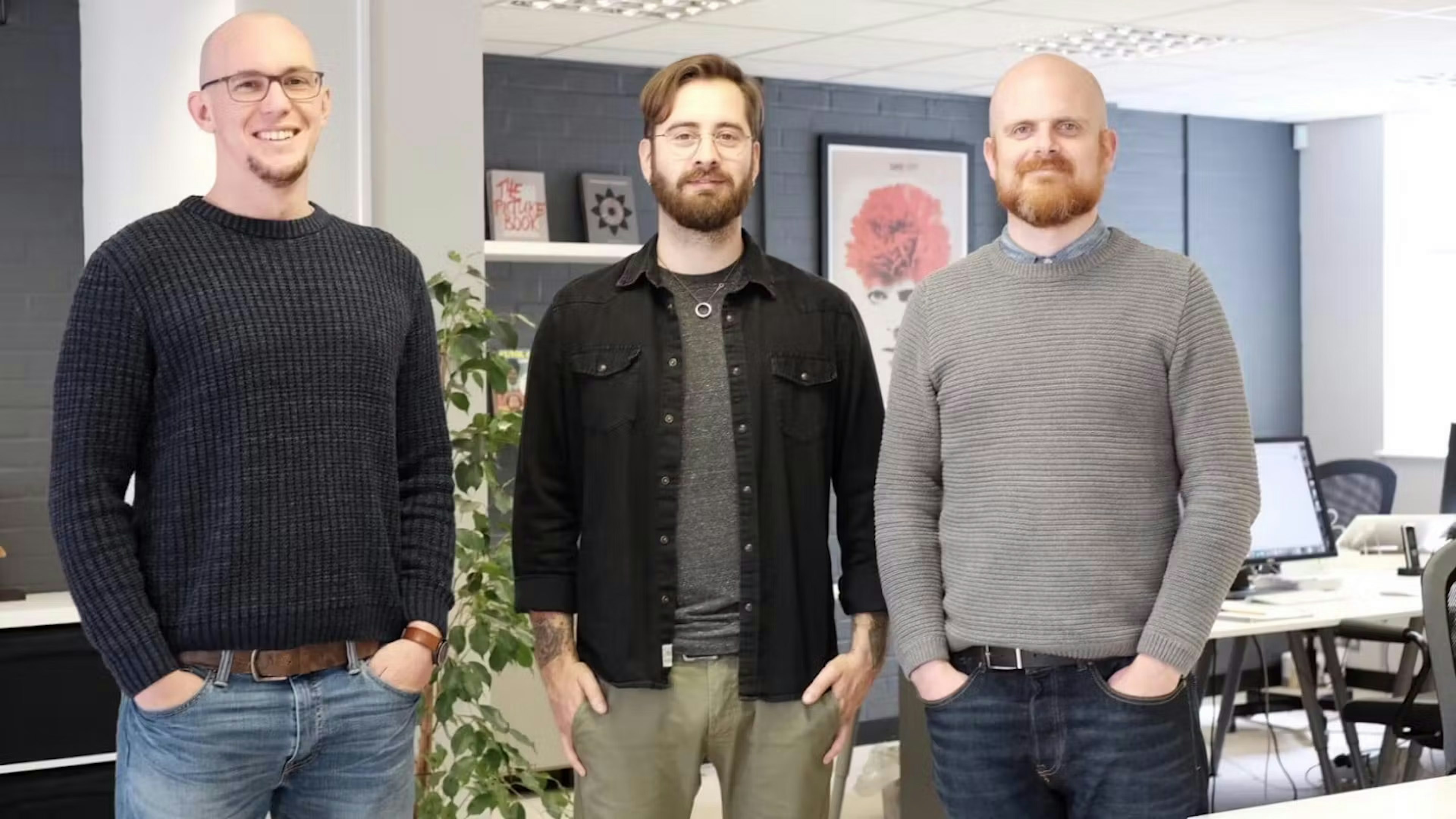 Mark, Max and John standing in a line in an office