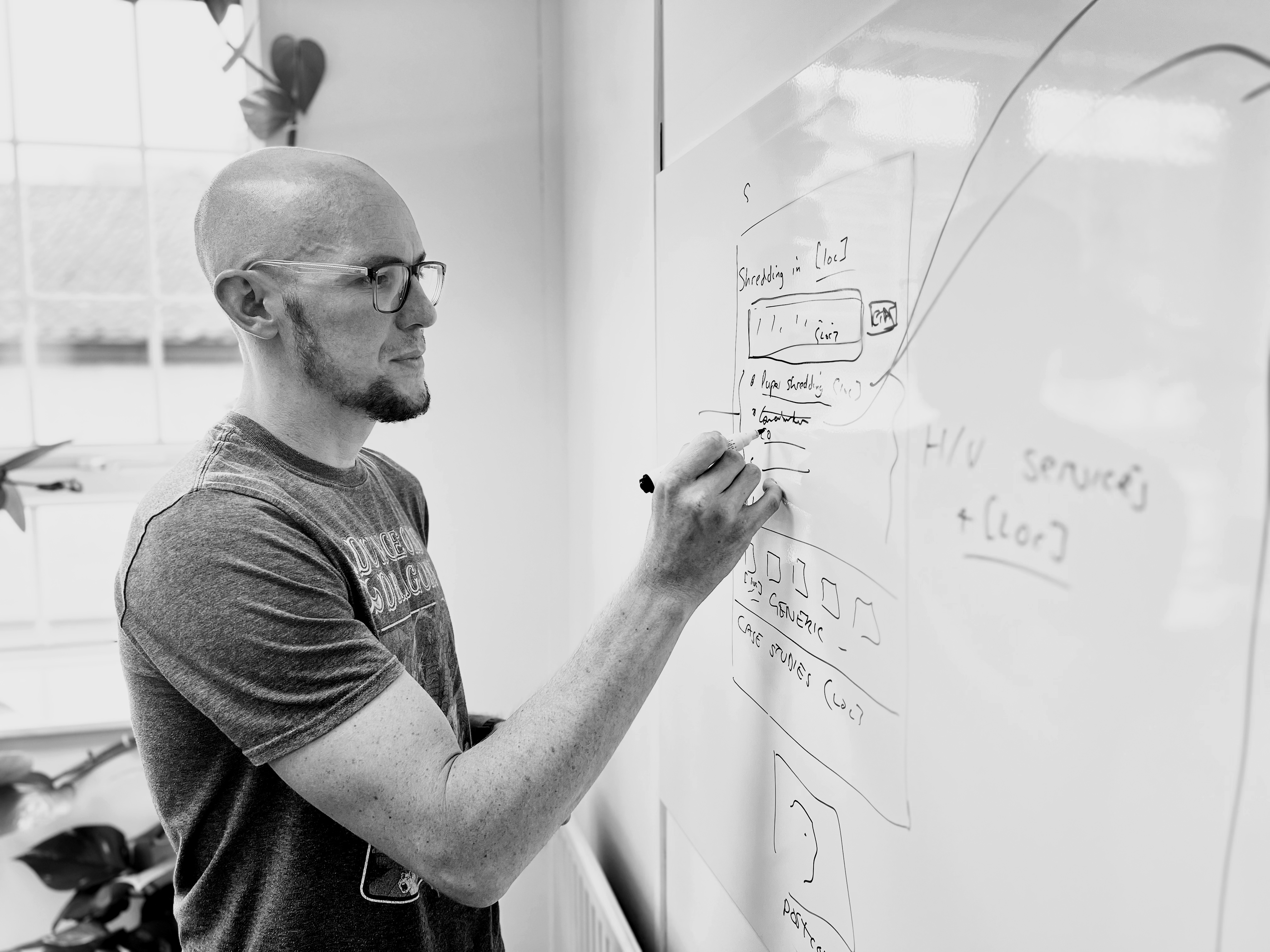 Mark Williams-Cook writing something very clever on a whiteboard in the Candour Agency office
