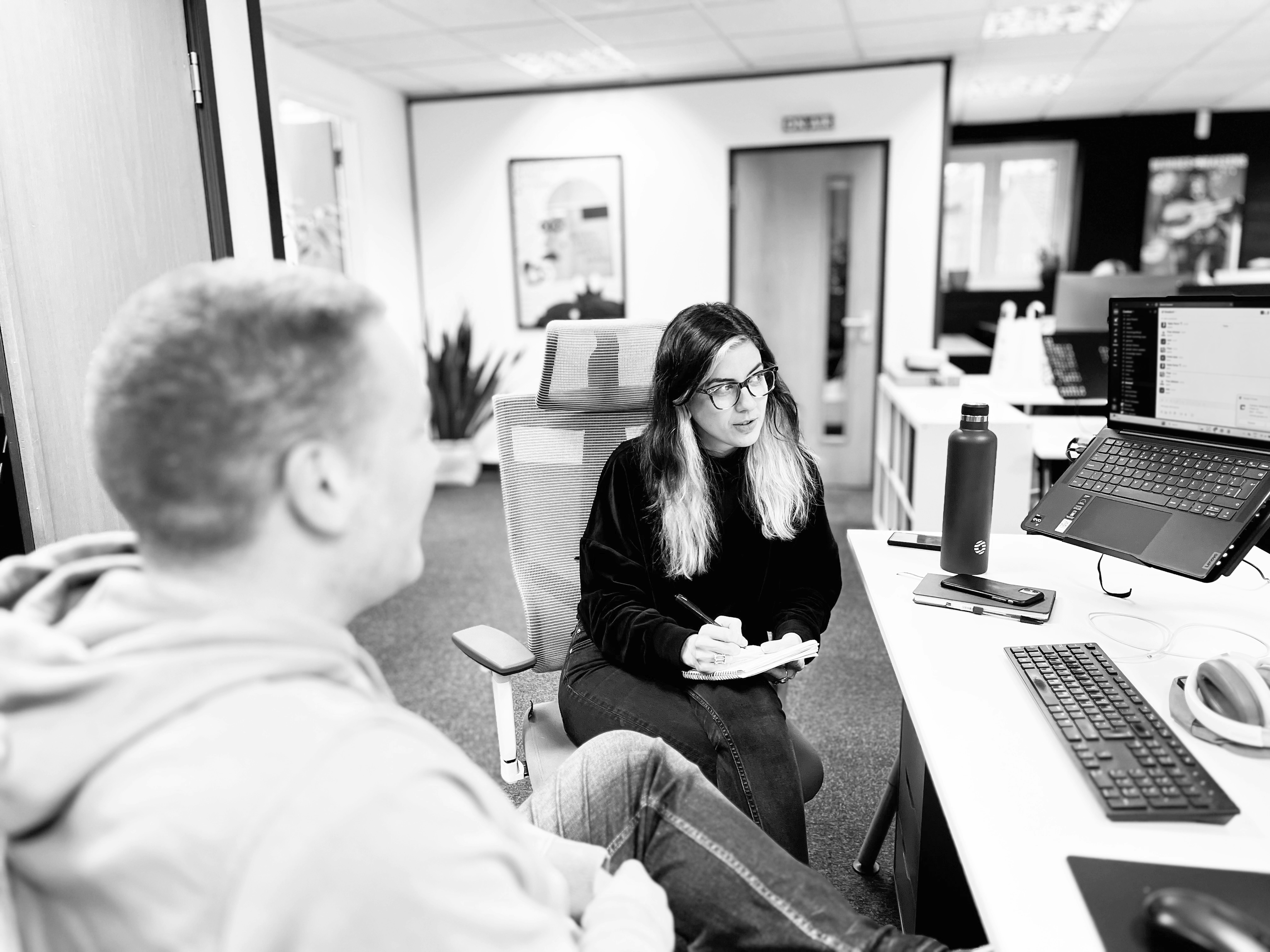 Two members of the Candour digital pr team sitting together at a desk to discuss some work