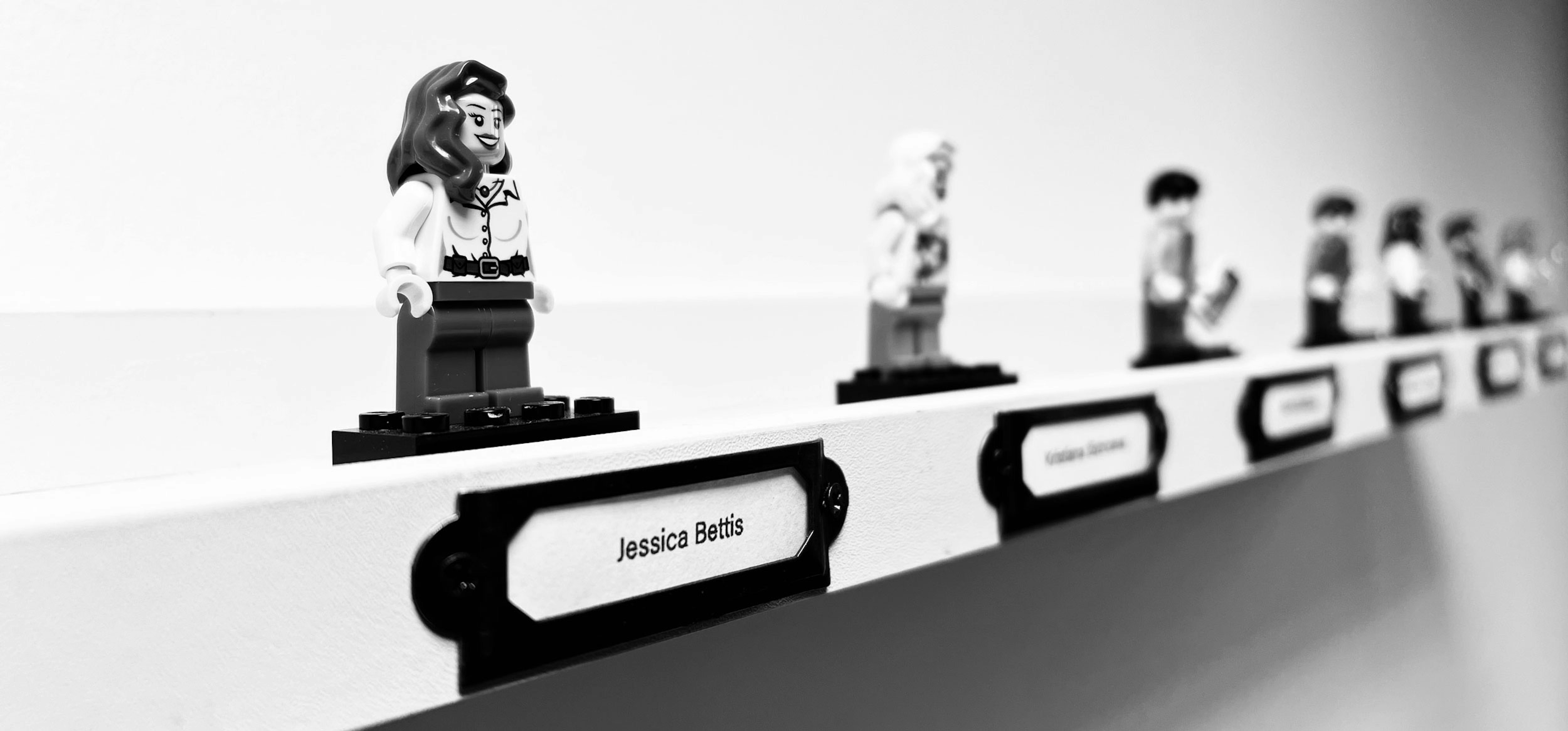 A shelf displaying lego figures representing Candour employees. Jessica Bettis' figure is in the foreground.