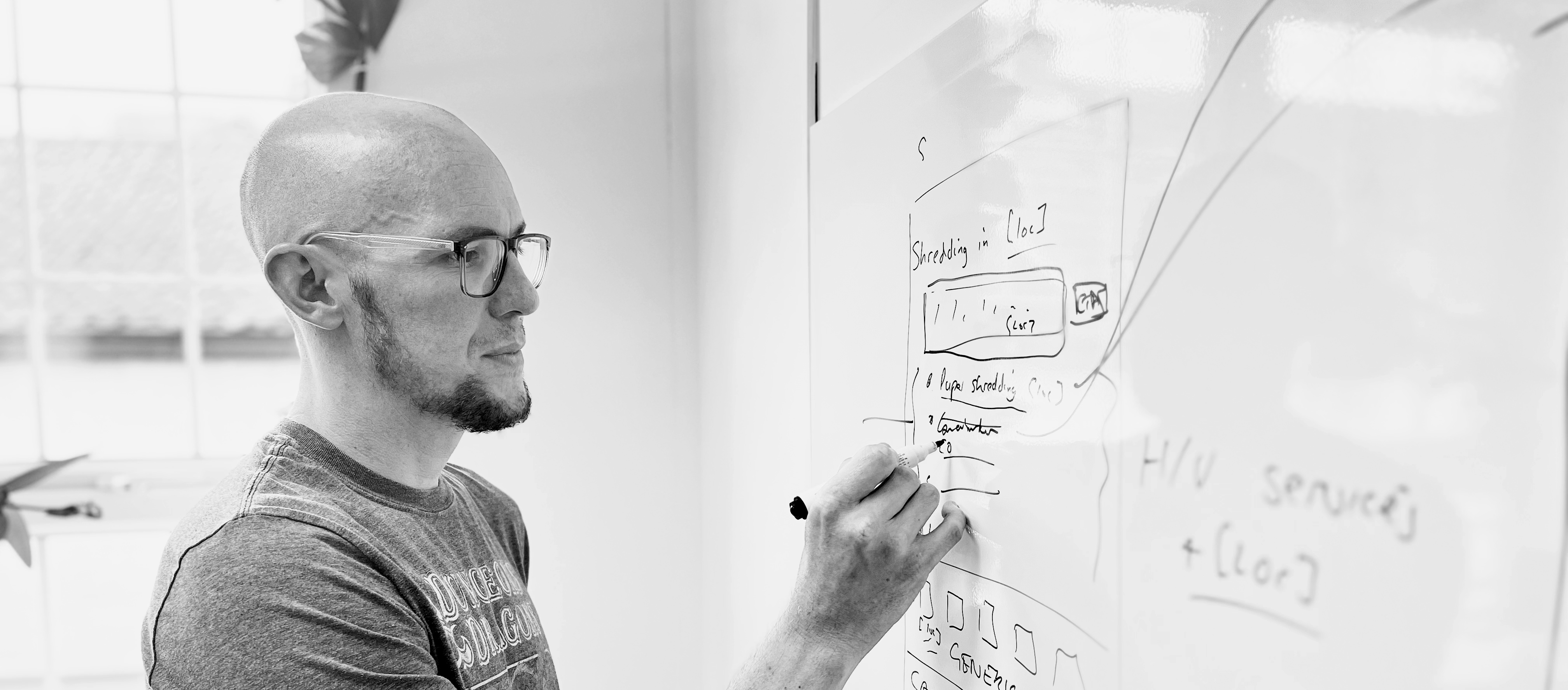 Mark Williams-Cook writing something clever on a whiteboard. He is thinking deeply, as he often does.