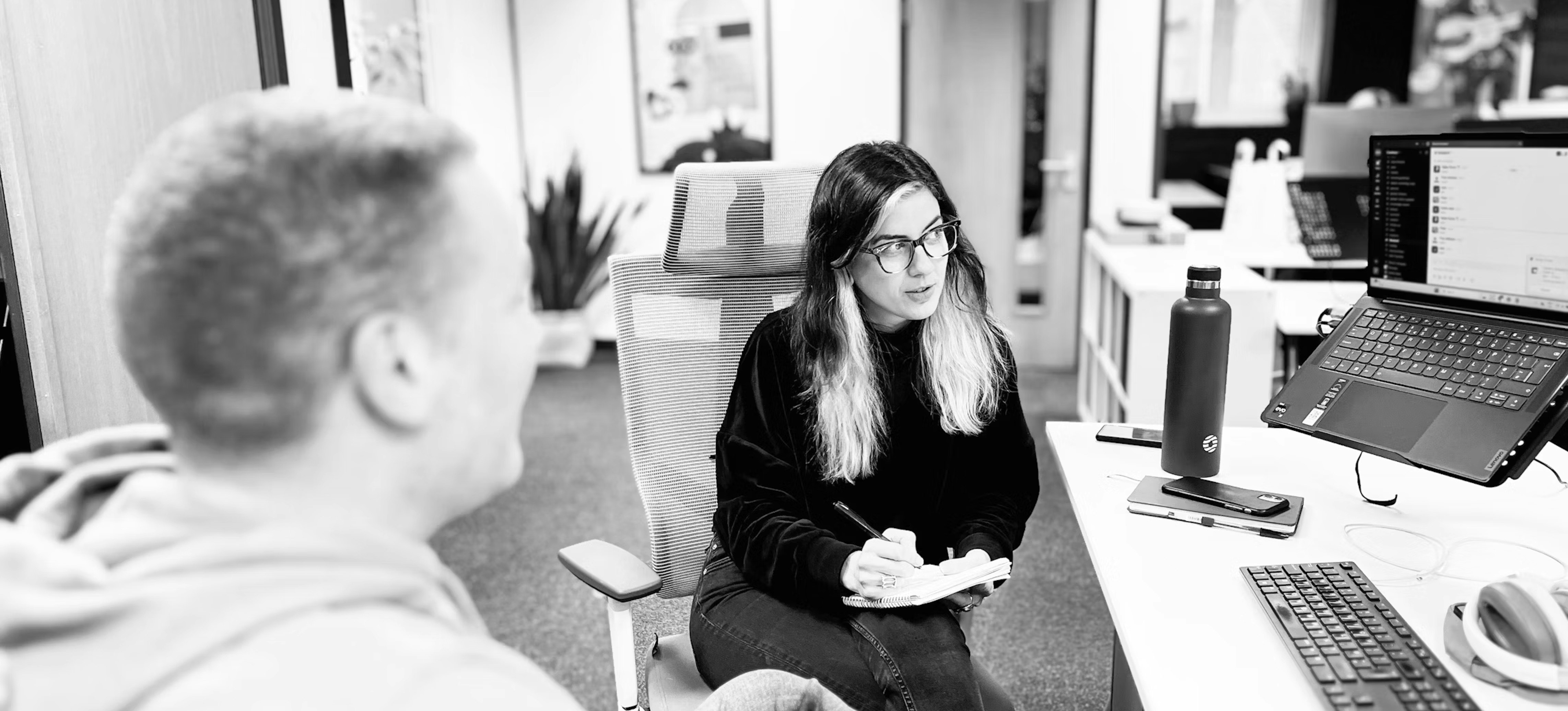 Two members of the Candour digital pr team, Terry Hearn and Tabby Farrar sitting together at a desk to discuss some work