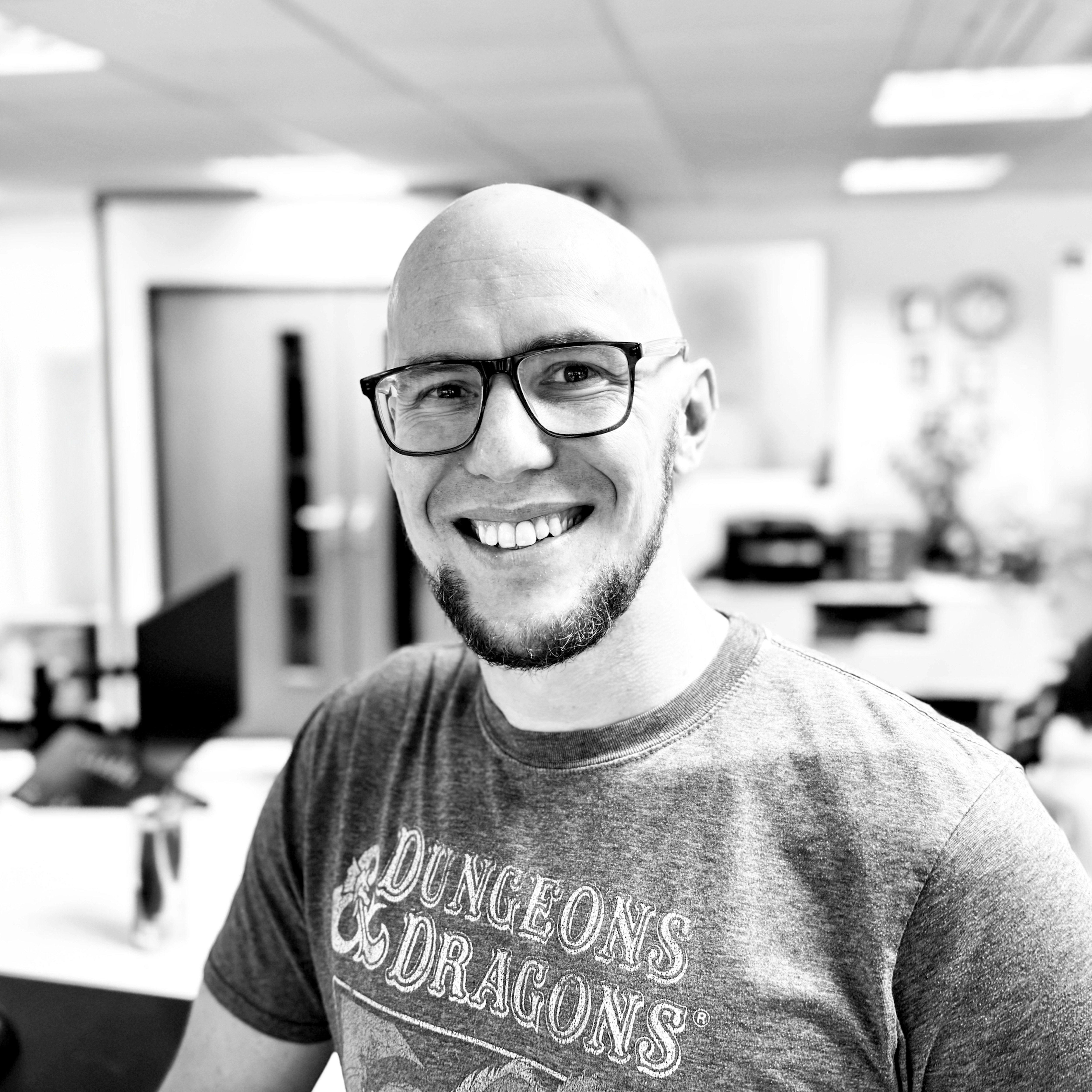 Mark Williams-Cook smiling at the camera. He is wearing a Dungeons and Dragons t shirt.